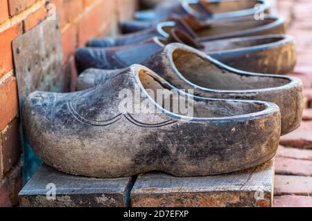 Pairs of old used dutch traditional wooden shoes or clogs in a row. Stock Photo