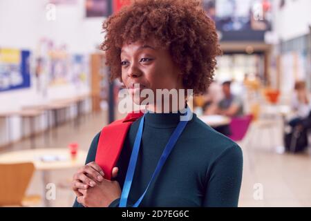 Portrait Of Smiling Female College Student In Busy Communal Campus Building Stock Photo