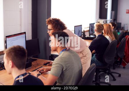Group Of College Students With Tutor Studying Computer Design Sitting At Monitors In Classroom Stock Photo
