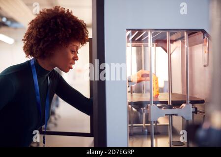 Female College Student Studying Engineering Using 3D Printing Machine Stock Photo