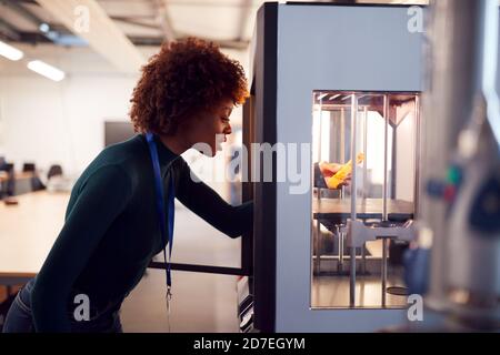 Female College Student Studying Engineering Using 3D Printing Machine Stock Photo