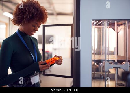 Female College Student Studying Engineering Using 3D Printing Machine Stock Photo