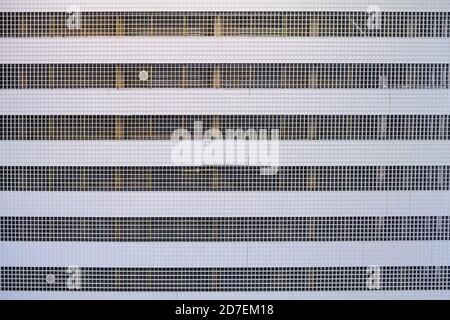 Metal grilles with many square holes in the steel ceiling, texture. Hi-tech industrial or office building interior aluminum fragment, background. Stock Photo