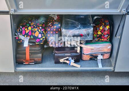 Checking luggage or suitcase compartment on bus. Many heavy luggage load into a bus locker. Packing bags while traveling. Suitcases in the luggage com Stock Photo