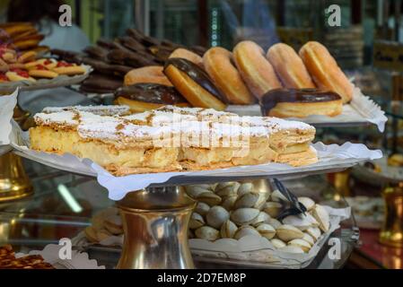 Sweet buns with cream in the window of a bakery. Stock Photo