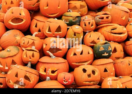 Halloween background of heap of carved Halloween pumpkins during the day. Stock Photo