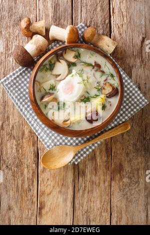 Kulajda is a Czech cuisine soup made with sour cream potatoes dill wild mushrooms and egg close-up in a bowl on the table. Vertical top view from abov Stock Photo