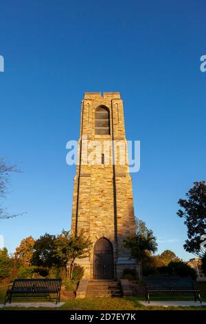autumn image of the Joseph D. Baker Tower and Carillon at sunset located in Baker Park, Frederick. Low angle bug eye image has clear blue sky in backg Stock Photo