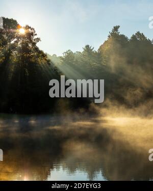 Sun rays coming through the trees onto water in the Blue Ridge Mountains. Stock Photo