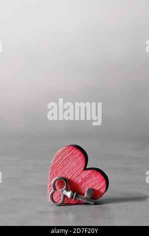 Silver key and red wooden heart on grey background. Valentines Day. Holiday concept. Stock Photo