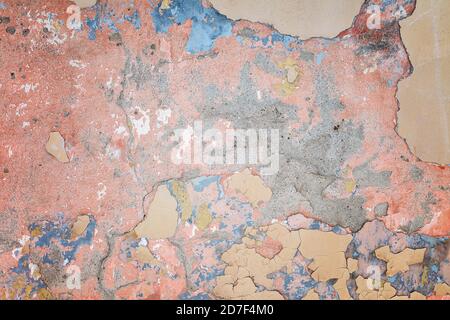Old plastered wall with peeling paint as a background. Stock Photo
