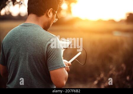 Drone controller man operating drone flying Stock Photo