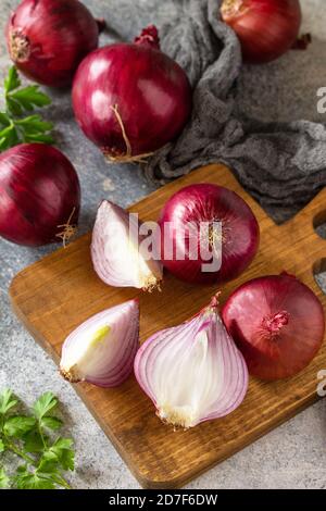 Purple Onions. Fresh whole purple onions and one sliced onion on a stone countertop. Stock Photo