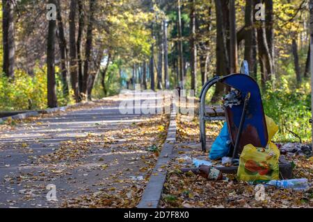 TULA, RUSSIA - OCTOBER 4, 2020: Overflowing trash can in lost park at daylight in early autumn. Stock Photo