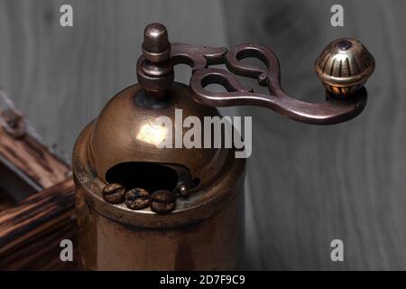 Close up of vintage coffee grinder with beans near wooden box Stock Photo