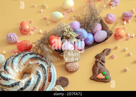 Easter composition with eggs and cupcake on a colored background. The concept of the Easter holidays. Stock Photo