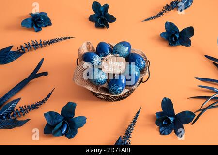 Creative Easter layout made of colorful eggs and flowers on blue background. Circle wreath flat lay concept. The concept of the Easter holidays. Stock Photo