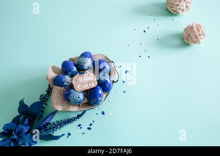 Creative Easter layout made of colorful eggs and flowers on blue background. Circle wreath flat lay concept. The concept of the Easter holidays. Stock Photo
