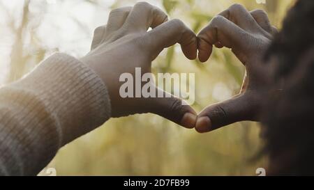 Young african man making heart shape with his hands in the woods. High quality photo Stock Photo
