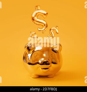 Golden piggy bank on yellow background with Gold USD Sign Balloons. Golden currency symbol made of inflatable foil balloon. Investment and banking Stock Photo
