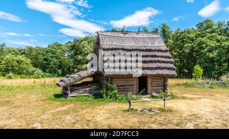 Small shepherd hut with straw roof on sunny day. Stock Photo