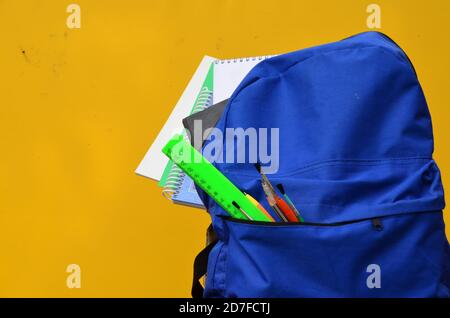 Full School backpack on yellow background. school supplies ruler, pencil, notebook, notepad Stock Photo