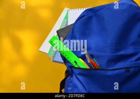 Full School backpack on yellow background. school supplies ruler, pencil, notebook, notepad Stock Photo