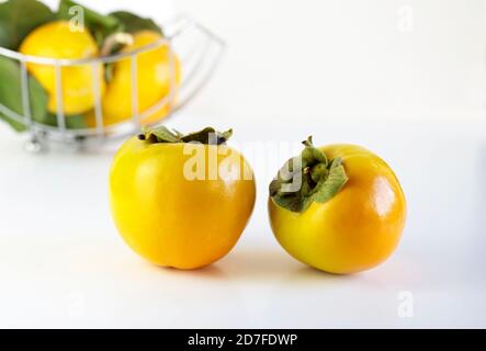 Fresh persimmons on white background Stock Photo