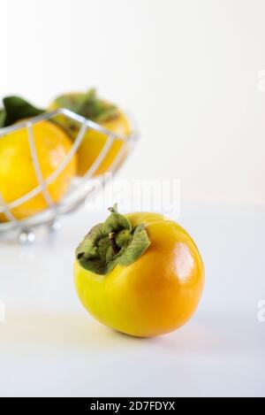 Fresh persimmons on white background Stock Photo