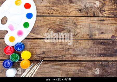 multi-colored paints,brushes palette, brush,lie on a wooden background top view Stock Photo