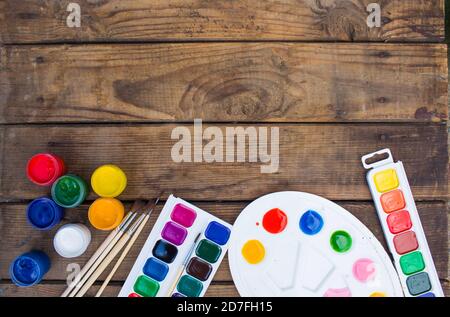 multi-colored paints,brushes palette, brush,lie on a wooden background top view Stock Photo