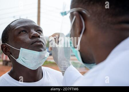 black lab scientist taking nasal sample from a man