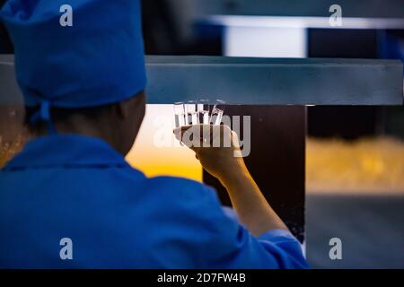 Shymkent/Kazakhstan - April 27 2012: Chemical pharmaceutical plant. Producing liquid dosage form ampules. QC of production on lighting device. Stock Photo