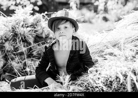 Portrait of a cheerful boy lying in a hay. Sale for entire autumn collection, incredible discounts and wonderful choice. Happy childhood. The boy Stock Photo