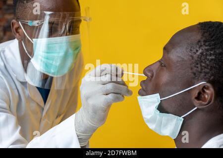 black medical personnel taking nasal sample for covid-19 testing