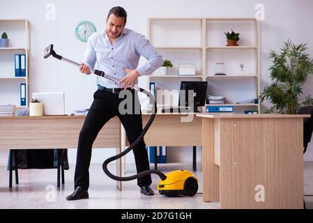 Young employee businessman cleaning office during pandemic Stock Photo