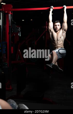 Athlete Performing Hanging Leg Raises Exercise - One Of The Most Effective Ab Exercises Stock Photo