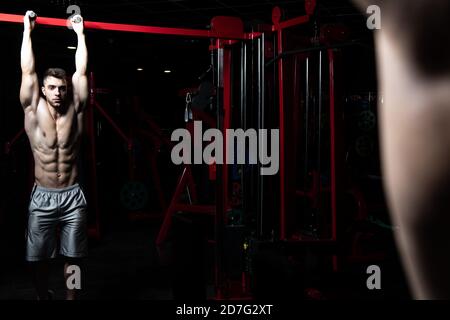 Athlete Performing Hanging Leg Raises Exercise - One Of The Most Effective Ab Exercises Stock Photo