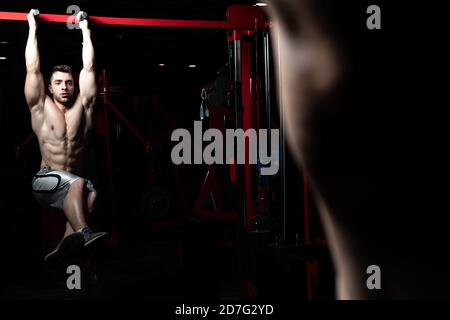 Athlete Performing Hanging Leg Raises Exercise - One Of The Most Effective Ab Exercises Stock Photo