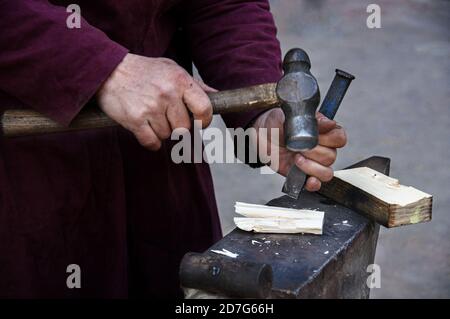 Closeup of carpenter hands working on the wood with his hammer Stock Photo