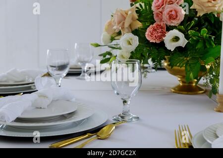 Table setting with beautiful flowers on the table in restaurant. Stock Photo