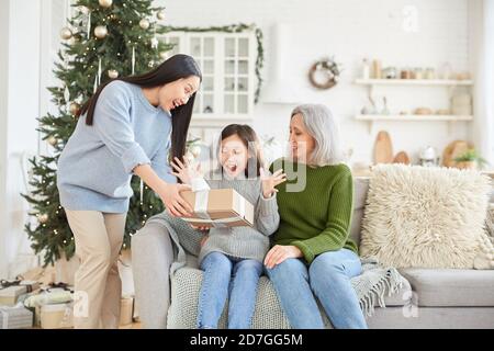 Little girl happy with present giving by her elder sister on Christmas Day Stock Photo