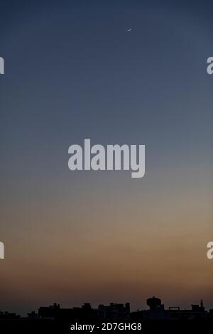 View of golden hour with blue and orange sky against the backdrop of a small Indian town skyline Stock Photo