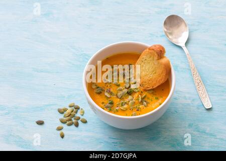 Pumpkin soup with pumpkin seeds and thyme on a blue background Stock Photo