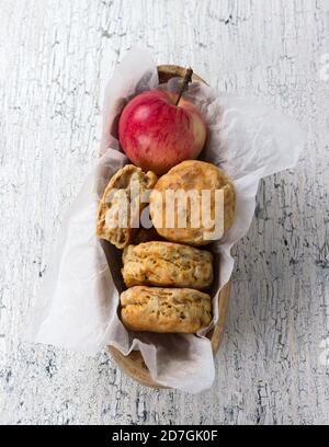 Apple scones in a wooden bowl on a white vintage surface, top view Stock Photo