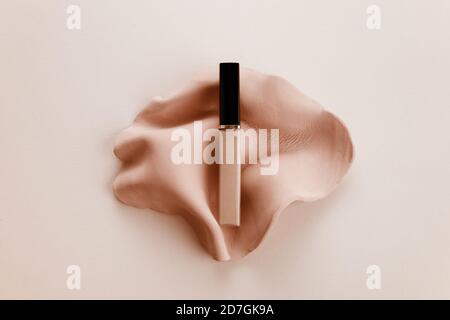 Cosmetic liquid foundation on biege background. Top view Stock Photo