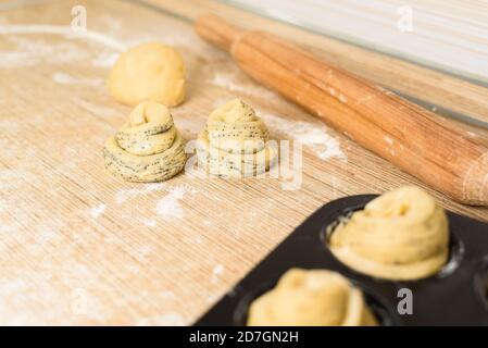 https://l450v.alamy.com/450v/2d7gn2h/raw-cruffins-before-baking-in-the-oven-in-an-iron-mold-puff-pastry-croissant-similar-to-a-muffin-rolled-into-a-roll-modern-baking-close-up-space-f-2d7gn2h.jpg