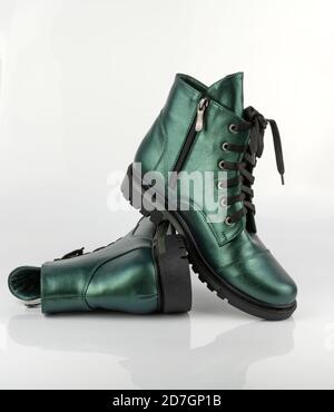 Leather green shoes. Winter shoes with fur. Sheepskin inside, like insulation. Stylish boot isolated on a white background. Close-up. Laces, tractor Stock Photo