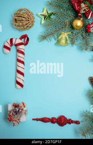 Christmas composition of Christmas toys, candy and spruce branches on a blue background. Stock Photo