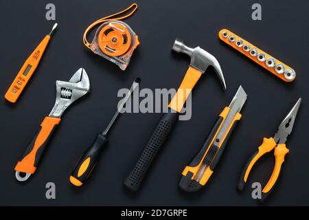 Set of tools on black background. Construction, DIY concept. Equipment,  workplace. Flat lay composition. Screwdriver, tape measure, wrench, knife, ha Stock Photo